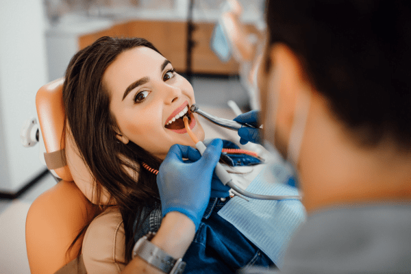A dentist performing a root canal treatment on a patient, focusing on the intricate procedure with specialized tools while the patient is comfortably seated in the dental chair.
